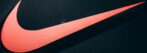 Vibrant red Nike swoosh logo displayed on a dark, minimalist backdrop symbolizing sports and lifestyle.